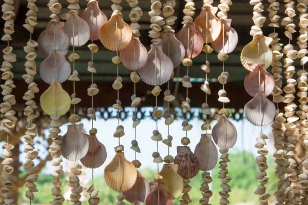 Cortina de conchas e elementos naturais em ambiente iluminado