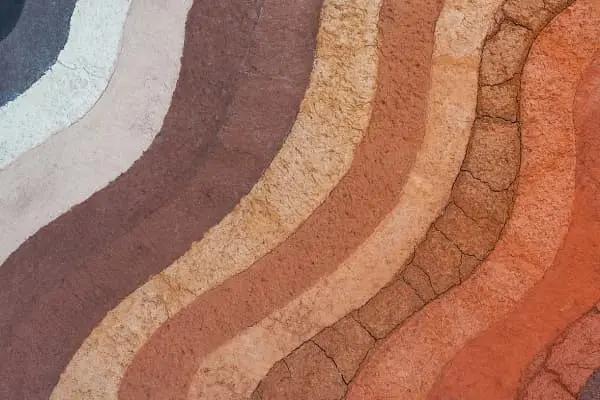 Camadas coloridas de terra compactada formando curvas naturais
